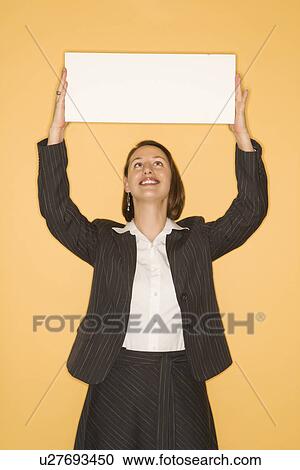 Businesswoman smiling holding blank sign View Large Photo Image Stock Image - Businesswoman smiling holding blank sign. Fotosearch