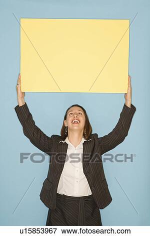 Businesswoman smiling holding blank sign View Large Photo Image Stock Photo - Businesswoman smiling holding blank sign. Fotosearch