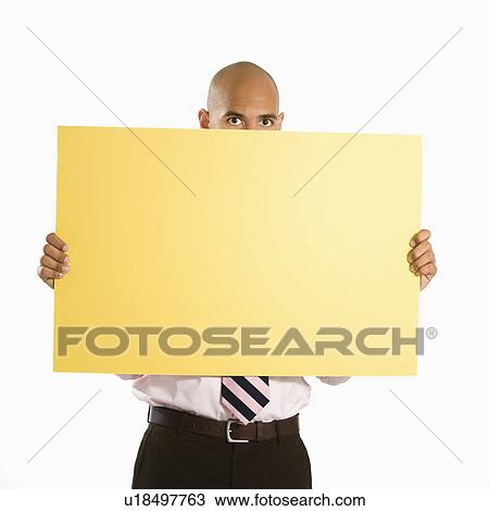 Man holding and peeking over blank yellow sign View Large Photo Image Stock Image - Man holding and peeking over blank yellow sign. Fotosearch