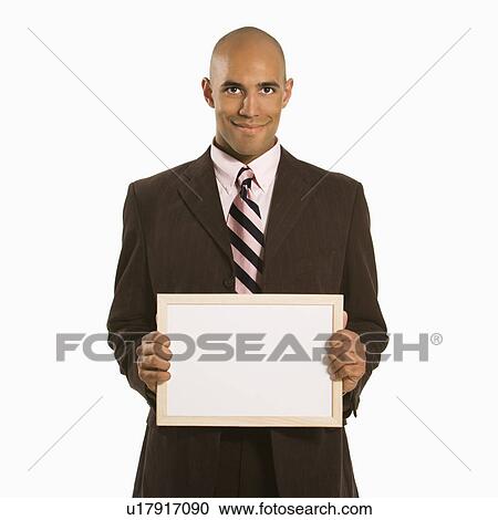 Stock Image - Man holding blank sign standing against white background. Fotosearch