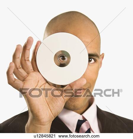Man holding compact disc over face and peeking through hole View Large Photo Image Stock Image - Man holding compact disc over face and peeking through hole. Fotosearch