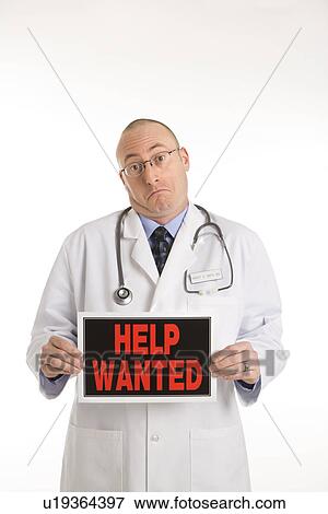 Physician holding help wanted sign View Large Photo Image Stock Photo - Physician holding help wanted sign. Fotosearch