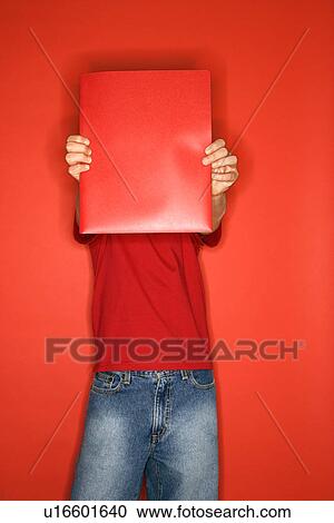 Portrait of boy covering his face with red folder standing against red background View Large Photo Image Stock Image - Portrait of boy covering his face with red folder standing against red background. Fotosearch