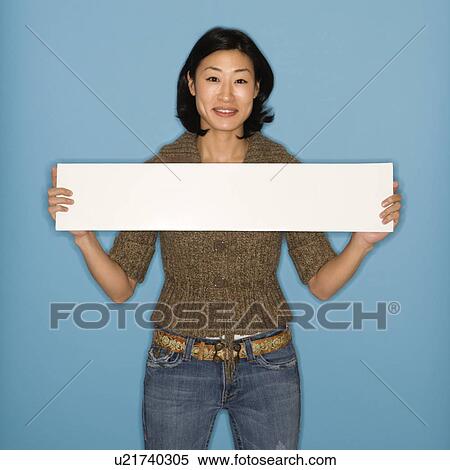 Woman holding blank sign on blue background View Large Photo Image Stock Photography - Woman holding blank sign on blue background. Fotosearch