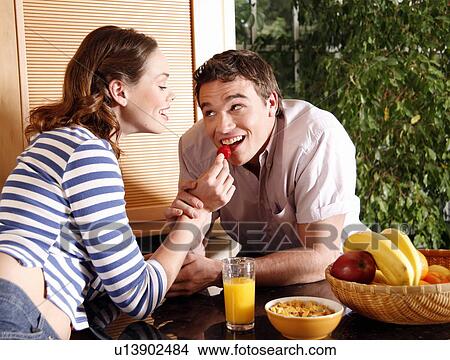 A young couple eating breakfast View Large Photo Image Picture - A young couple eating breakfast. Fotosearch