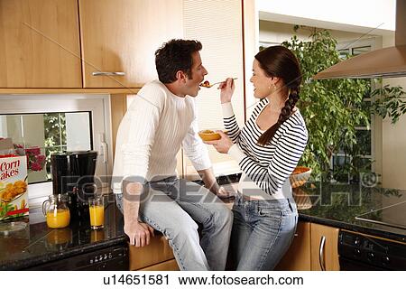 A young couple eating breakfast View Large Photo Image Stock Image - A young couple eating breakfast. Fotosearch