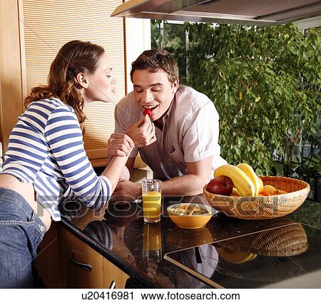 A young couple eating breakfast View Large Photo Image Stock Image - A young couple eating breakfast. Fotosearch