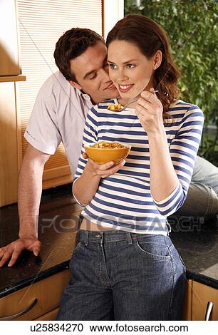 Stock Image - A young couple eating breakfast. Fotosearch