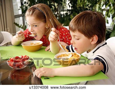 Children eating breakfast View Large Photo Image Stock Photo - Children eating breakfast. Fotosearch