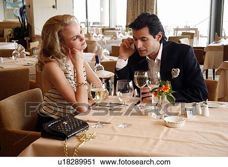 Stock Image - Couple having a romantic moment in a restaurant. Fotosearch