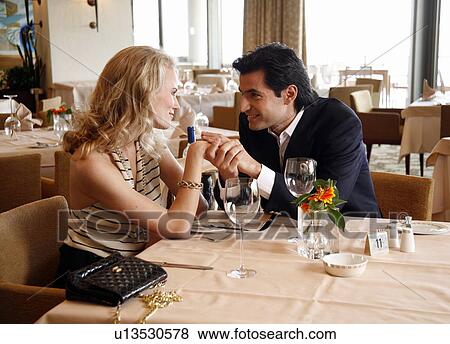 Couple having a romantic moment in a restaurant View Large Photo Image Stock Photo - Couple having a romantic moment in a restaurant. Fotosearch