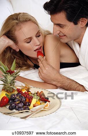 Stock Photo - Couple relaxing in bed. Fotosearch