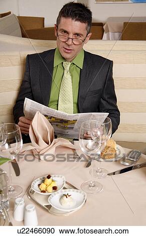 Stock Image - Man sitting at the table in a restaurant. Fotosearch