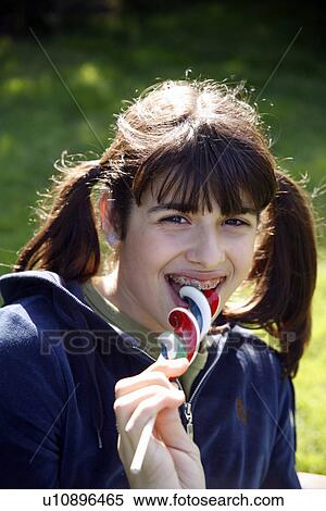 Teenage girl licking a lollipop View Large Photo Image Stock Photography - Teenage girl licking a lollipop. Fotosearch