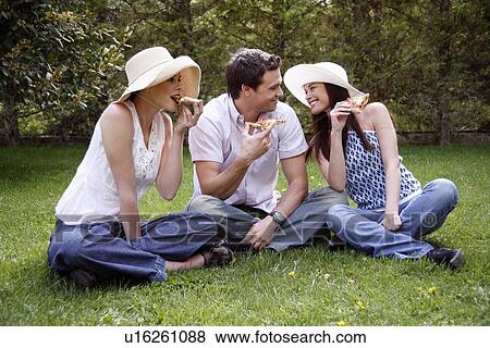 Three friends eating pizza View Large Photo Image Stock Photo - Three friends eating pizza. Fotosearch
