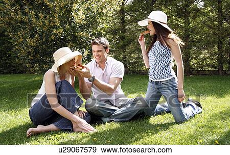 Stock Photo - Three friends eating pizza. Fotosearch