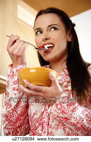 Picture - Woman eating her breakfast. Fotosearch