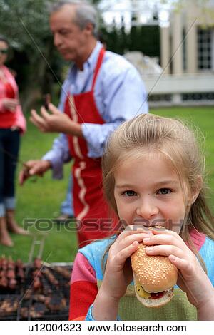 Young girl eating a hot dog View Large Photo Image Stock Image - Young girl eating a hot dog. Fotosearch