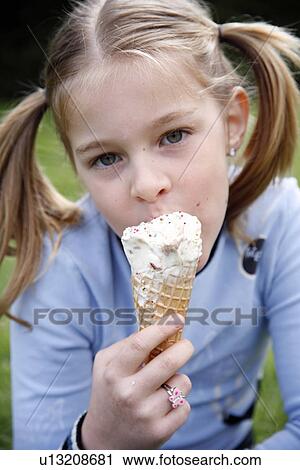 Young girl eating ice cream View Large Photo Image Stock Image - Young girl eating ice cream . Fotosearch