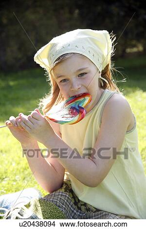 Young girl licking a lollipop View Large Photo Image Picture - Young girl licking a lollipop. Fotosearch