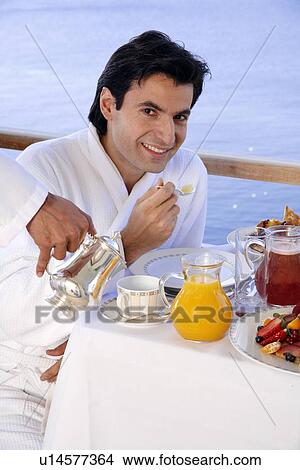 Young man having breakfast on hotel terrace View Large Photo Image Picture - Young man having breakfast on hotel terrace. Fotosearch