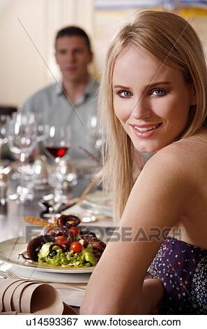 Stock Photo - Young woman dining in a restaurant. Fotosearch