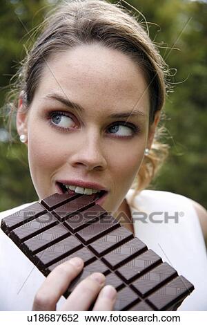 Young woman eating chocolate View Large Photo Image Stock Image - Young woman eating chocolate. Fotosearch