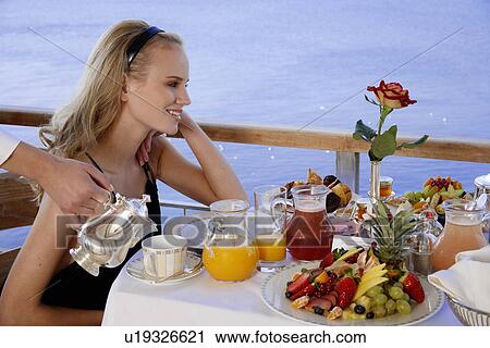 Young woman having breakfast on hotel terrace View Large Photo Image Stock Image - Young woman having breakfast on hotel terrace. Fotosearch