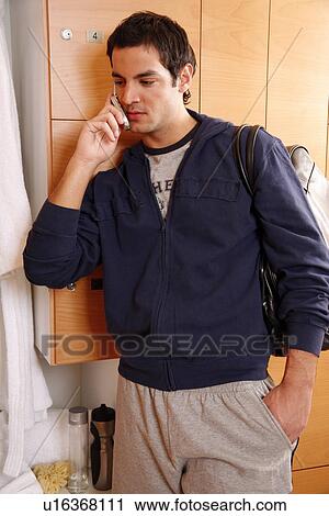 Man in locker room after work out talking on cell phone View Large Photo Image Stock Image - Man in locker room after work out talking on cell phone. Fotosearch