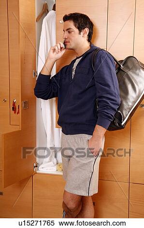 Man in locker room after work out talking on cell phone View Large Photo Image Stock Photography - Man in locker room after work out talking on cell phone. Fotosearch