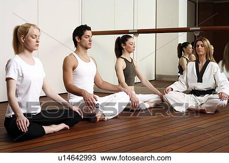 Participants in a fitness class meditating View Large Photo Image Stock Image - Participants in a fitness class meditating. Fotosearch