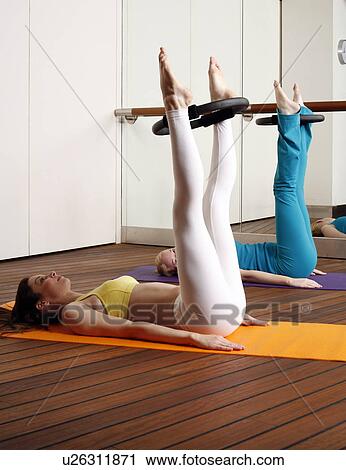 Two young women performing a pilates exercise View Large Photo Image Stock Image - Two young women performing a pilates exercise. Fotosearch