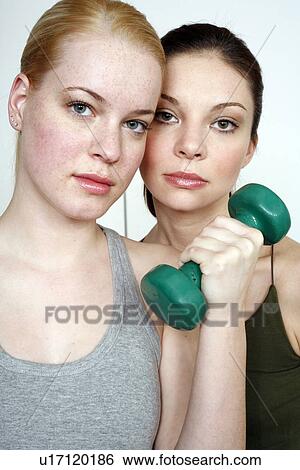 Two young women with dumbbell View Large Photo Image Stock Photograph - Two young women with dumbbell. Fotosearch
