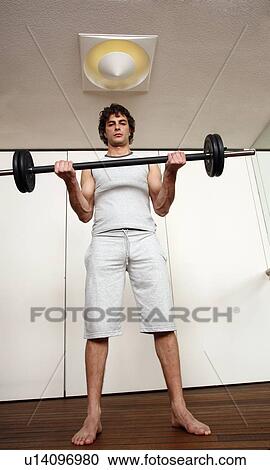 Young man lifting weights View Large Photo Image Stock Image - Young man lifting weights. Fotosearch