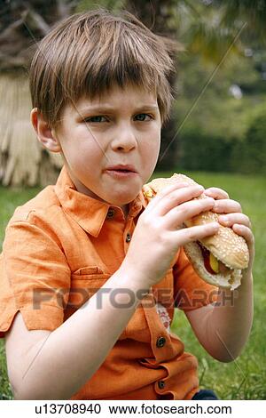 Young boy eating a hot dog View Large Photo Image Stock Image - Young boy eating a hot dog. Fotosearch