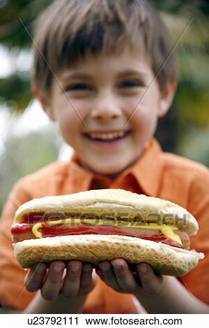 Young boy eating a hot dog View Large Photo Image Stock Image - Young boy eating a hot dog. Fotosearch