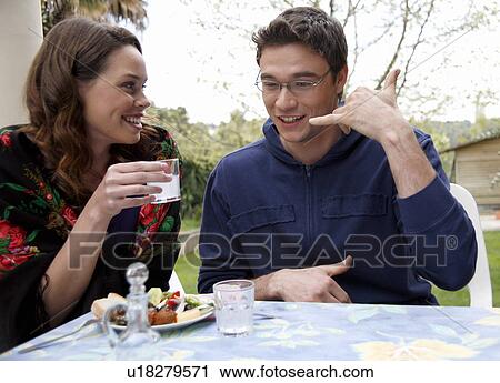 Stock Image - Young couple drinking ouzo. Fotosearch