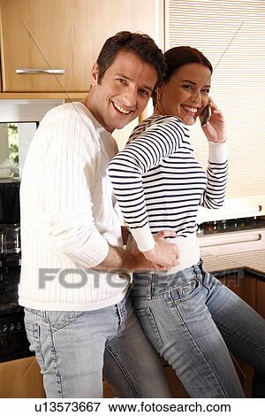 Stock Photo - A young couple in the kitchen. Fotosearch