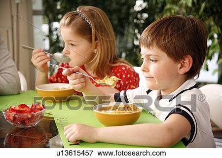 Stock Photo - Children eating breakfast. Fotosearch