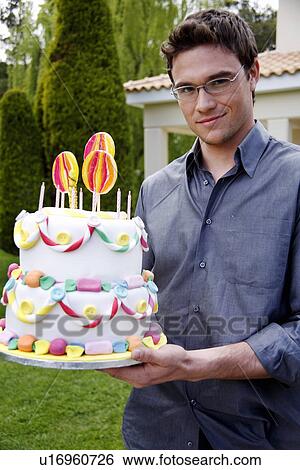 Man holding party cake View Large Photo Image Stock Photograph - Man holding party cake. Fotosearch