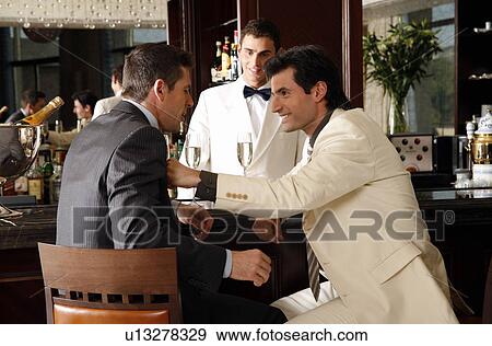 Two men in agreement at a bar View Large Photo Image Stock Photo - Two men in agreement at a bar. Fotosearch
