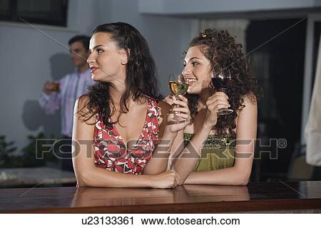 Stock Image - Two women in a bar. Fotosearch