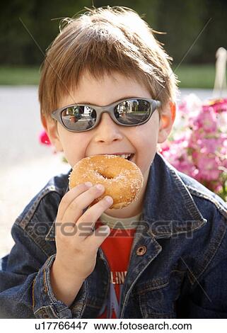 Stock Photo - Young boy eating a doughnut. Fotosearch