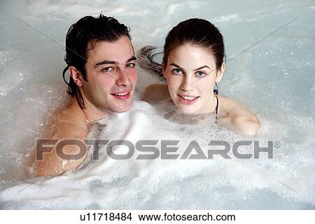 Picture - One man with woman in jacuzzi at a spa. Fotosearch
