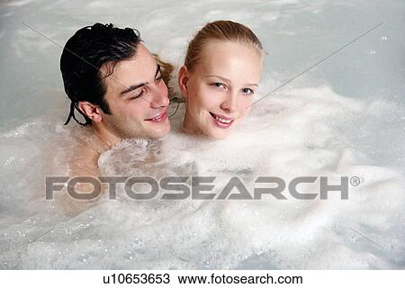 Stock Image - One man with woman in jacuzzi at a spa. Fotosearch