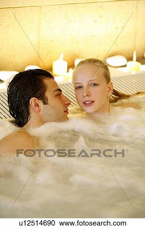 Stock Image - One man with woman in jacuzzi at a spa. Fotosearch