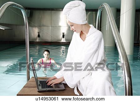 Woman on computer next to a swimming pool View Large Photo Image Stock Image - Woman on computer next to a swimming pool. Fotosearch