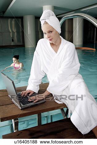 Woman on computer next to a swimming pool View Large Photo Image Stock Photo - Woman on computer next to a swimming pool. Fotosearch