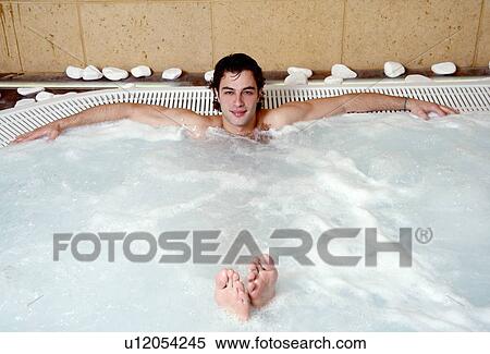 Stock Photography - Young man in jacuzzi at a spa. Fotosearch