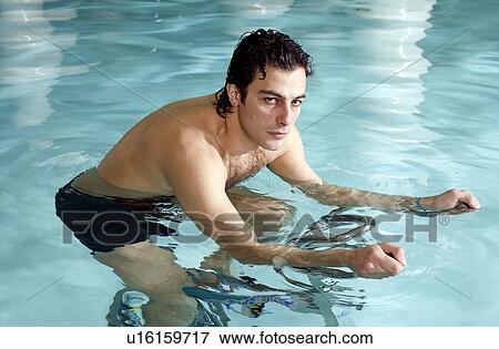 Young man on exercise bike in spa pool View Large Photo Image Stock Photo - Young man on exercise bike in spa pool. Fotosearch